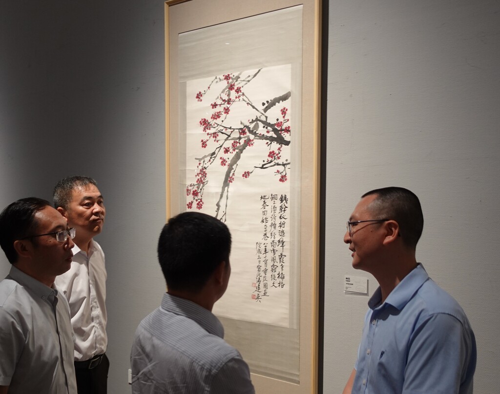 重庆美术馆（重庆画院）副馆长、副院长唐德福向观展嘉宾介绍展出中的冯建吴作品
